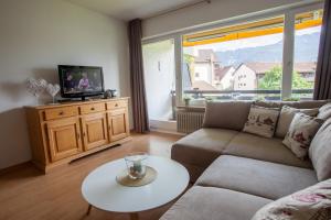 salon z kanapą, telewizorem i stołem w obiekcie Alpenzauber Whg.25 w Garmisch Partenkirchen