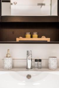 a bathroom counter with a sink with three containers on it at Augusta Street 213 - 3 Dto - Your Home in Lisbon in Lisbon