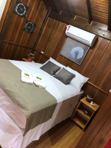 una camera da letto con un letto con due asciugamani sopra di CASA DI PECORA - POUSADA RURAL a Lauro Müller