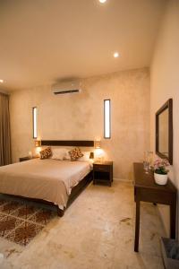 - une chambre avec un lit, deux tables et un miroir dans l'établissement Hotel Boutique SAYAB, à Valladolid