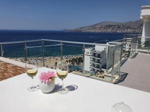 - une table avec des verres à vin et une vue sur la plage dans l'établissement Sadet's Penthouse Saranda, à Saranda