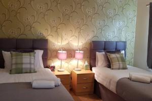 ein Schlafzimmer mit 2 Betten und 2 Lampen an Tischen in der Unterkunft Delight Marvel-Derby House at Maidstone in Maidstone