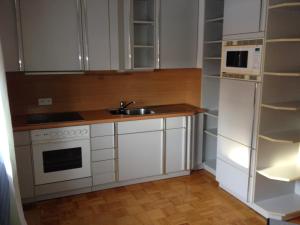 a kitchen with white cabinets and a sink and a microwave at Gästehaus Stapf in Oberaurach