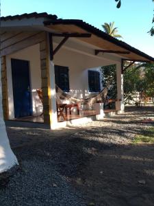 ein Haus mit einer Veranda mit einem Tisch und Stühlen in der Unterkunft Chales Adria in Porto De Galinhas