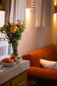 un vase de fleurs et de fruits sur un comptoir avec canapé dans l'établissement Hotel Boutique SAYAB, à Valladolid
