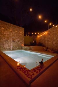 - une piscine avec bougies et lumières la nuit dans l'établissement Hotel Boutique SAYAB, à Valladolid