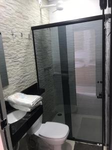 a bathroom with a toilet and a glass shower at Hotel Flor Paulista in São Paulo