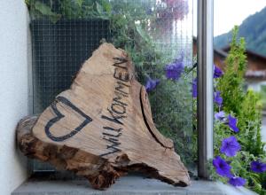 a piece of wood sitting next to some purple flowers at Panoramablick in Schruns-Tschagguns