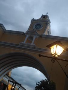 un bâtiment avec une tour d'horloge éclairée dans l'établissement Casa Landivar Hotel, à Antigua Guatemala