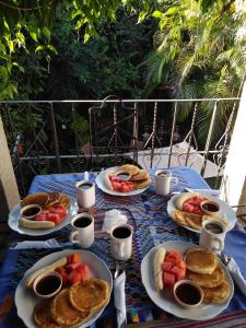 a table with plates of pancakes and fruit on it at Casa Landivar Hotel in Antigua Guatemala