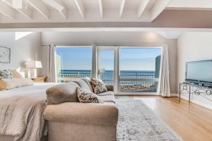 a bedroom with a large bed and a large window at Big O Beach - White Sands Townhomes in Pensacola Beach