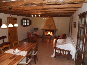 ein Wohnzimmer mit einem Tisch und einem Kamin in der Unterkunft Cal Solsona in La Baronia de Rialb