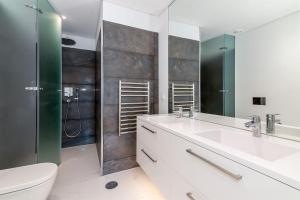 a bathroom with two sinks and a toilet and a shower at The Boulevard by The Good Neighbour in Lisbon in Lisbon +20 photos