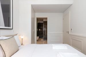 a bedroom with a white bed and a bathroom at The Boulevard by The Good Neighbour in Lisbon in Lisbon