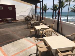 a patio with tables and chairs and the beach at Hotel San Diego in Mazatlán