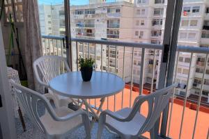 ein Tisch und Stühle auf einem Balkon mit einem Tisch und einer Pflanze in der Unterkunft 150m2 Con vistas al Mar y al Castillo de Cullera in Cullera