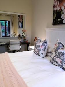 a bedroom with a white bed with two pillows on it at Andante Lodge in Pretoria