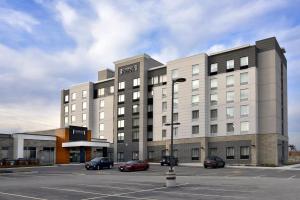 Un gran edificio con coches aparcados en un estacionamiento. en Staybridge Suites - Waterloo - St. Jacobs Area, en Waterloo