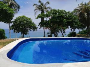 a blue swimming pool with the ocean in the background at Hotel Villa Mexicana Puerto Escondido in Puerto Escondido +7 photos