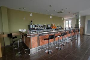a bar with a row of stools in a room at Hotel Palacio de Asturias in Oviedo
