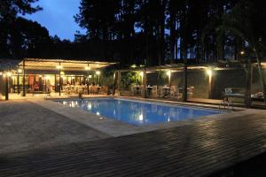 a swimming pool in front of a restaurant at night at Espaço Vila Lara in São Roque