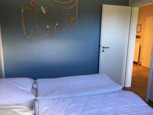 Wulfen auf FehmarnにあるFerienwohnung-Franzmannの青い壁のベッドルームのベッド1台