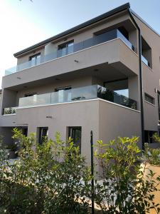 een appartementencomplex met balkons en bomen bij Casa Rovigno in Rovinj