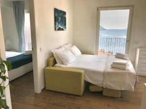 a bedroom with a bed with a view of the ocean at Wind Rose Apartments in Nago-Torbole