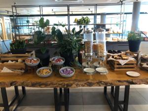 a table filled with bowls of food and plants at Slaviero Campina Grande in Campina Grande