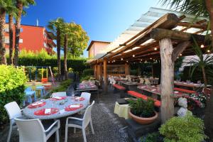 a patio with tables and chairs and a restaurant at Osteria Ticino by Ketty & Tommy in Ascona