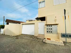 a house with two garage doors and a driveway at Ilha de Rhodes in Bombinhas