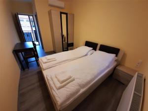 A bed or beds in a room at Bársony Vendéglő és Panzió