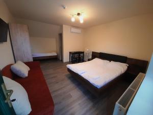 1 dormitorio con 2 camas y mesa. en Bársony Vendéglő és Panzió, en Szécsény