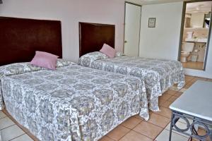 En eller flere senger på et rom på Hotel Posada Centenario
