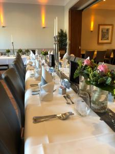 une grande table avec des assiettes et des serviettes dans l'établissement Hotel-Restaurant Große-Wilde, à Bottrop