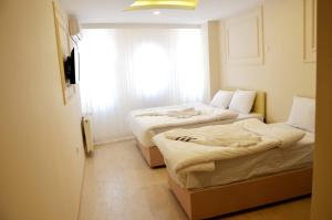 two beds in a room with a window at Sultanahmet çoşkun hotel in Istanbul