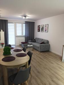 uma sala de estar com uma mesa e um sofá em Apartament Marcella em Gorzów Wielkopolski