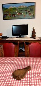 een tafel met een bureau met een computermonitor op een tafel bij GERFAUD Appartements en chalet in Saint-Gervais-les-Bains