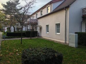 ein Haus mit einem Hof mit einem Baum und einem Gebäude in der Unterkunft Studio Meißner - Parkresidenz Dierhagen in Dierhagen