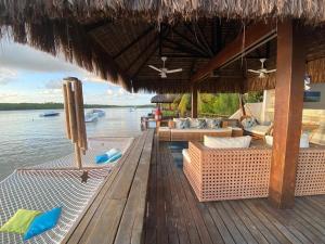 Casa praia Porto de Galinhas Toquinho في إيبوجوكا: منتجع فيه كراسي وطاولات على سطح خشبي