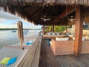 a resort with chairs and tables on a wooden deck at Casa praia Porto de Galinhas Toquinho in Ipojuca