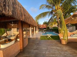 ein Resort mit einer Terrasse mit Stühlen und einem Pool in der Unterkunft Casa praia Porto de Galinhas Toquinho in Ipojuca