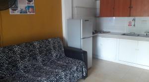 a kitchen with a black and white chair and a refrigerator at Posada Nativa Miss Zelzel Place in San Andrés