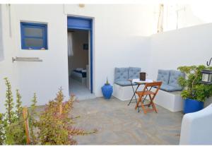 a patio with two chairs and a table at Tsakonas Plakes Studios in Plaka Milou