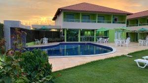 a villa with a swimming pool and tables and chairs at Pousada Solar Dos Carneiros in Praia dos Carneiros