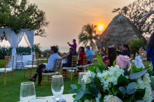 una mesa con un jarrón de flores sobre una mesa con puesta de sol en Atami Escape Resort, en La Libertad