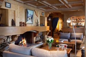 ein Wohnzimmer mit einem Kamin und einem Sofa in der Unterkunft Hôtel La Grange d'Arly in Megève