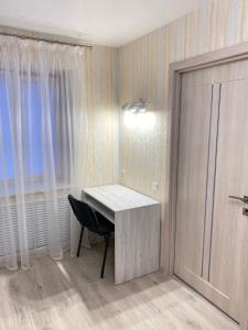 a room with a desk and a chair and a door at Suite Mira Avenue Center Двухкомнатная Квартира в центре возле ТЦ ЦУМ in Chernihiv