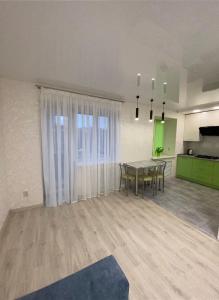 an empty living room with a table and a kitchen at Suite Mira Avenue Center Двухкомнатная Квартира в центре возле ТЦ ЦУМ in Chernihiv