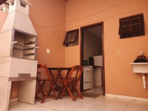 a room with two chairs and a table in a kitchen at Chales Mar Azul in Caraguatatuba +13 photos
